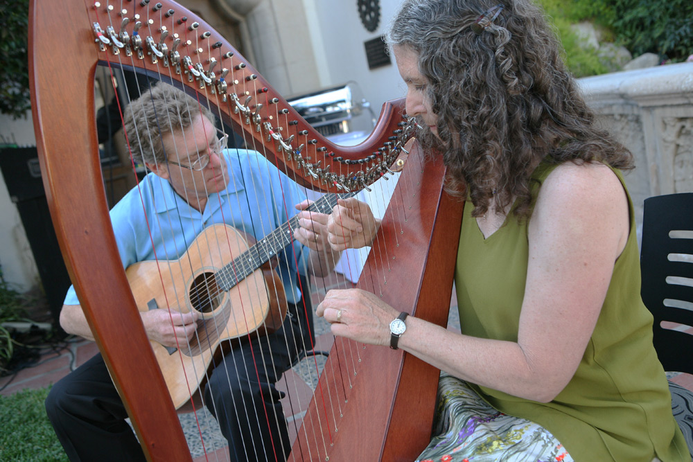 David playing one of his OM model guitars while Sharon plays an okoume Ceili 34 harp, 2009.