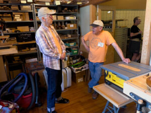 Dave Cohen (r), who organized the Science and Technology Seminar, talks with Tim in his shop next to the Guild office. (McElrath)