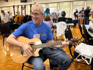 Robbie O'Brien enjoys trying out one of Jeffrey Yong's guitars. (Woo)