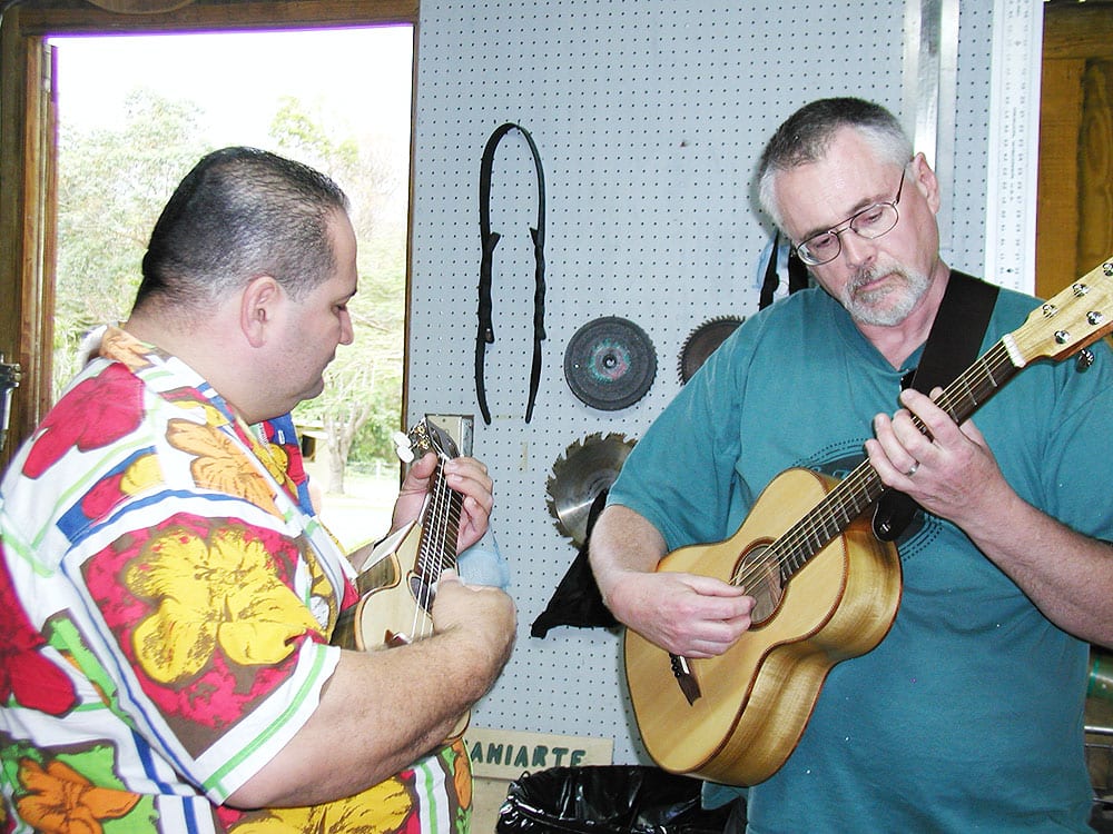 Author Fred Casey (right) plays the travel guitar he built for the conference while Edwin Colon Zayas plays a tiple.