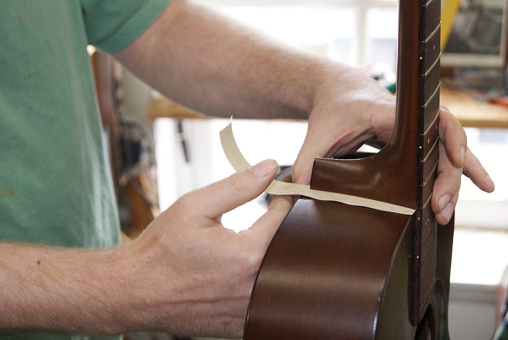 Lin Crowson in the Gruhn shop resets the neck on a vintage Martin guitar by “flossing” the neck joint. (image 1 of 4)