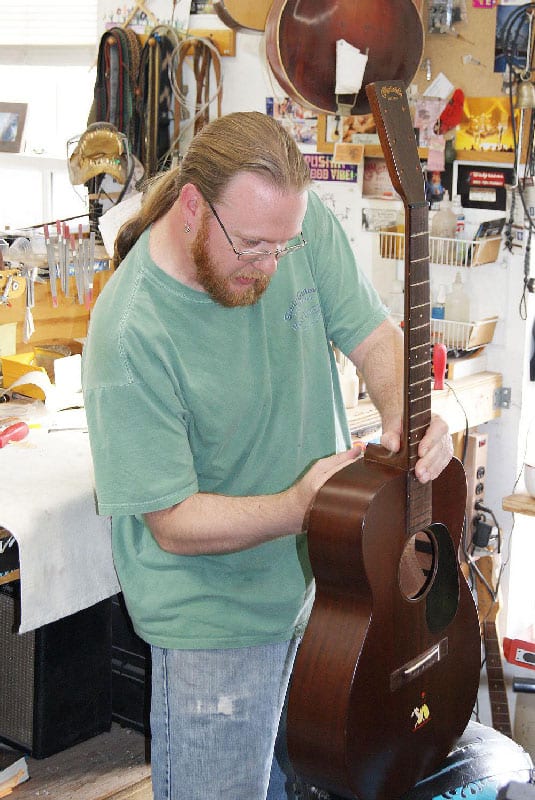 Lin Crowson in the Gruhn shop resets the neck on a vintage Martin guitar by “flossing” the neck joint. (image 4 of 4)