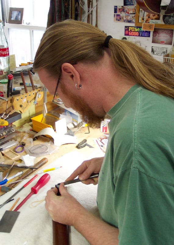 Lin Crowson in the Gruhn shop resets the neck on a vintage Martin guitar by “flossing” the neck joint. (image 3 of 4)