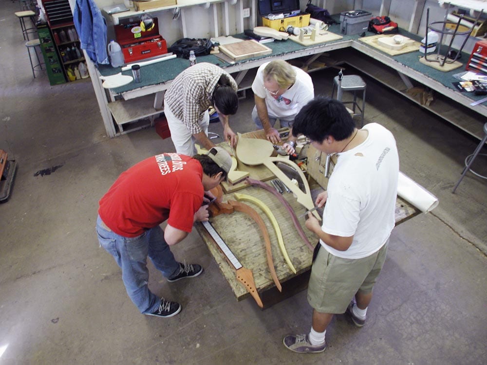 William Eaton supervises Roberto-Venn students making an electric harp guitar of his design, 2002. (image 1 of 3)