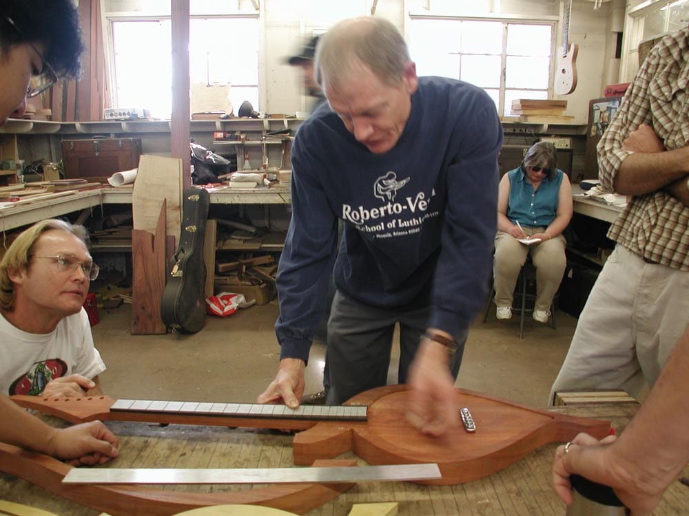 William Eaton supervises Roberto-Venn students making an electric harp guitar of his design, 2002. (image 2 of 3)