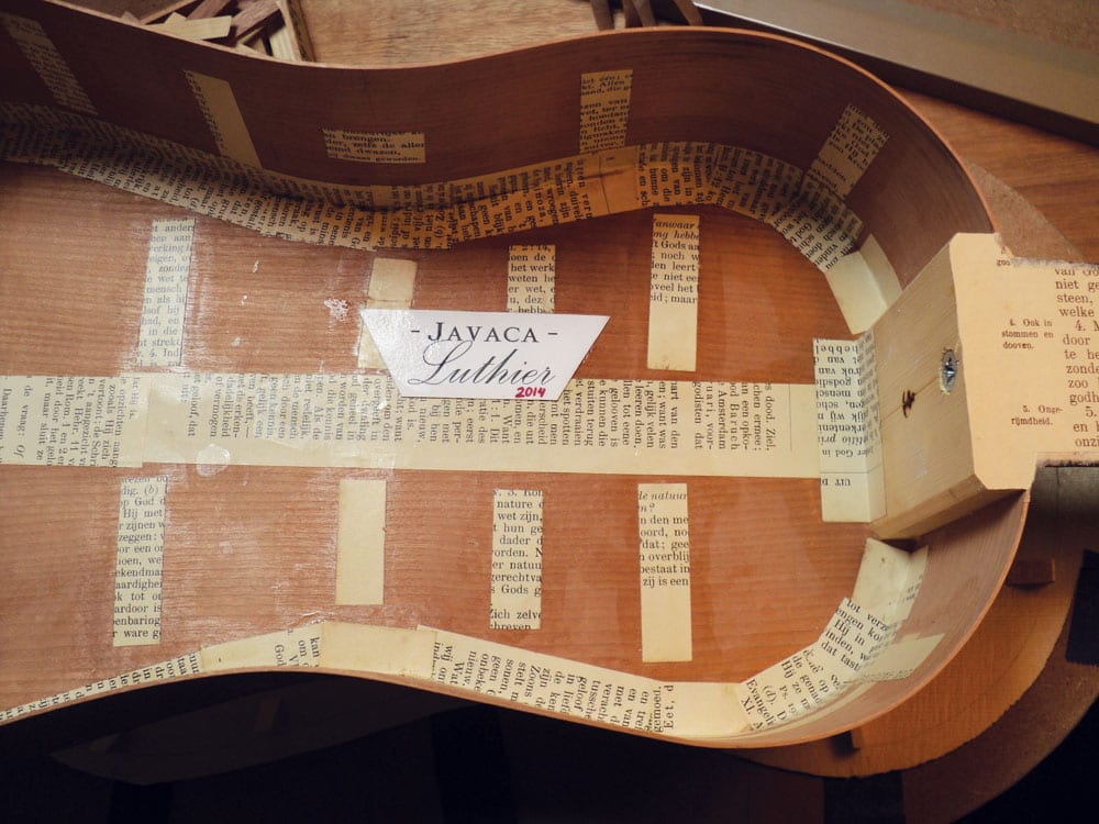 The paper-reinforced interior of the larger guitar.