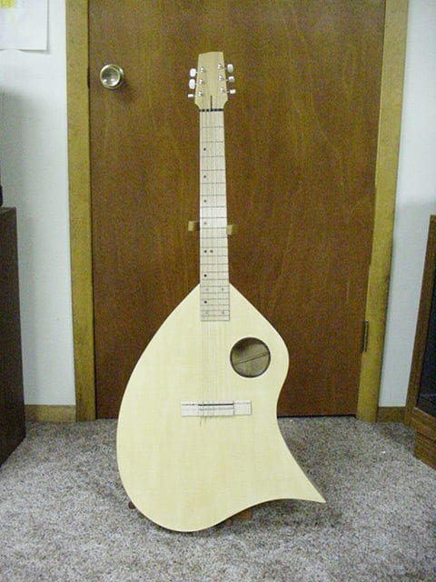 Here’s two more of my ergonomic guitars. This was the first one I made. The top was from a 2x12 from the lumber yard and the rest of it was from scraps I had. I think I figured it cost about $25 to make. The top was really thin and it sounded OK.