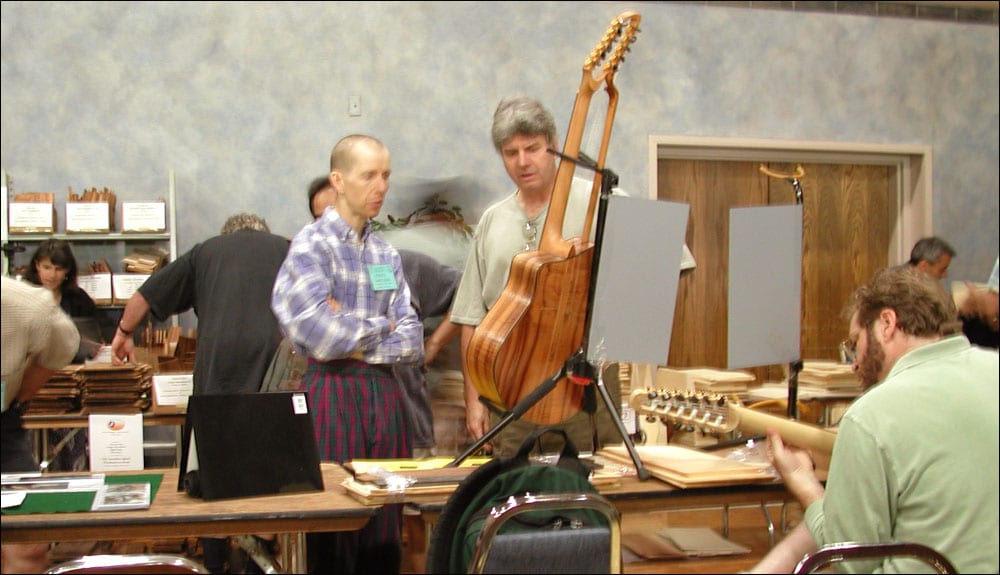 Showing his harp guitar to Fred Carlson.