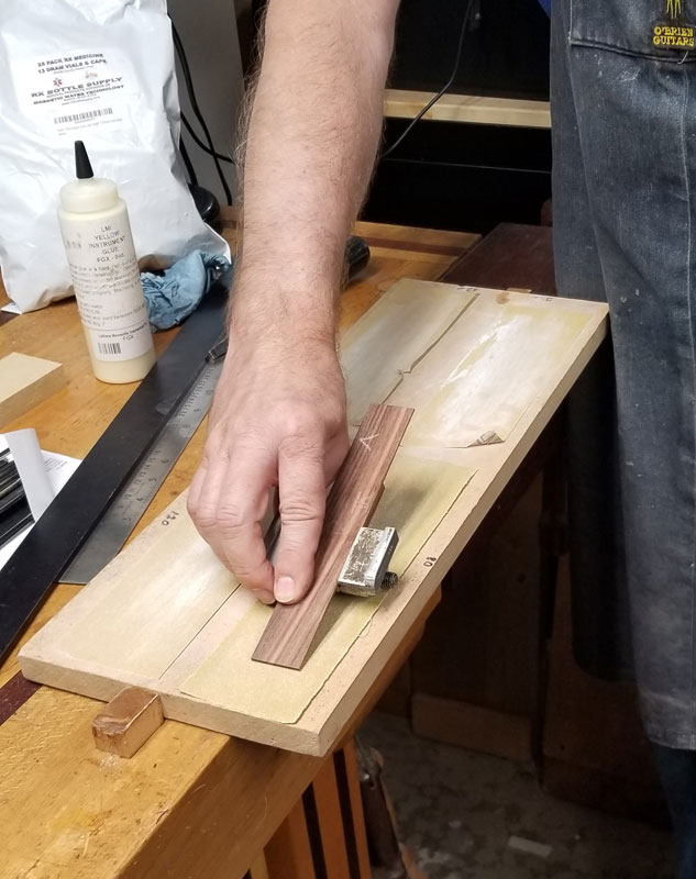 Here’s Robbie showing a cool way to do a nice bevel on the ends of a classical bridge – clamp it into a chisel sharpening jig.