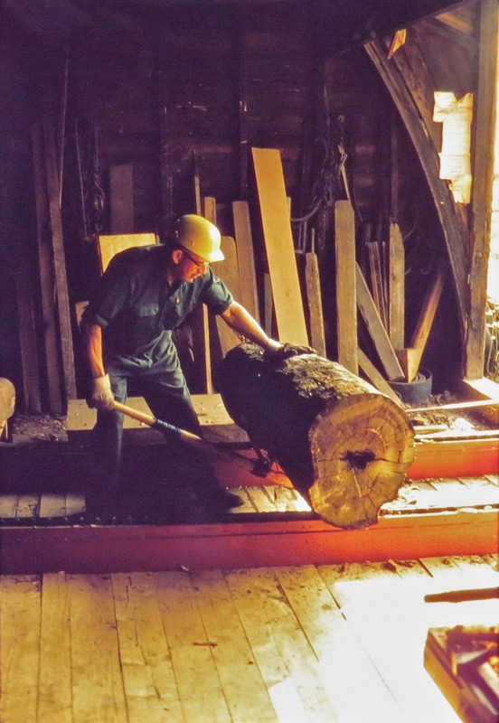 Jesse, a workman at the Doll Lumber and Veneer Company mill, rolls in a small Brazilian rosewood log.